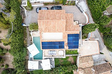 An aerial view of a house with solar panels on the roof
