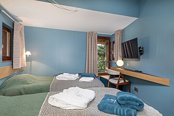 A hotel room with two beds and a flat screen tv