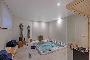 A hot tub in a bathroom next to a sauna