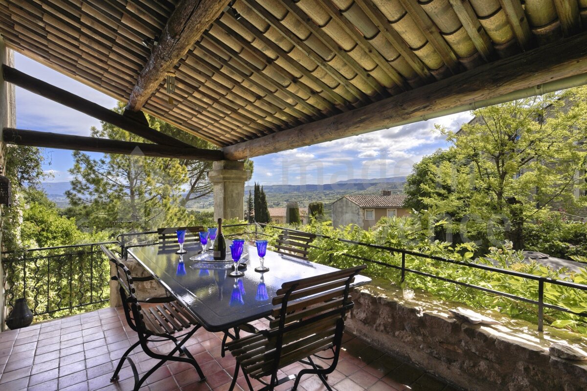 A table and chairs on a balcony with a view of the mountains