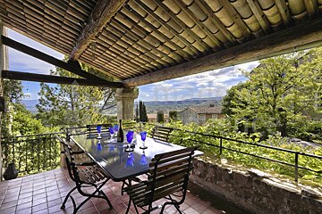 A table and chairs on a balcony with a view of the mountains