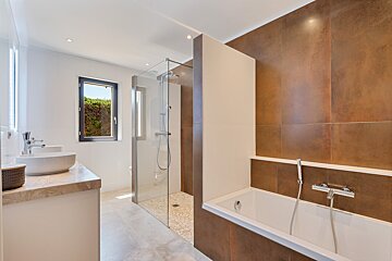 A bathroom with two sinks and a walk in shower