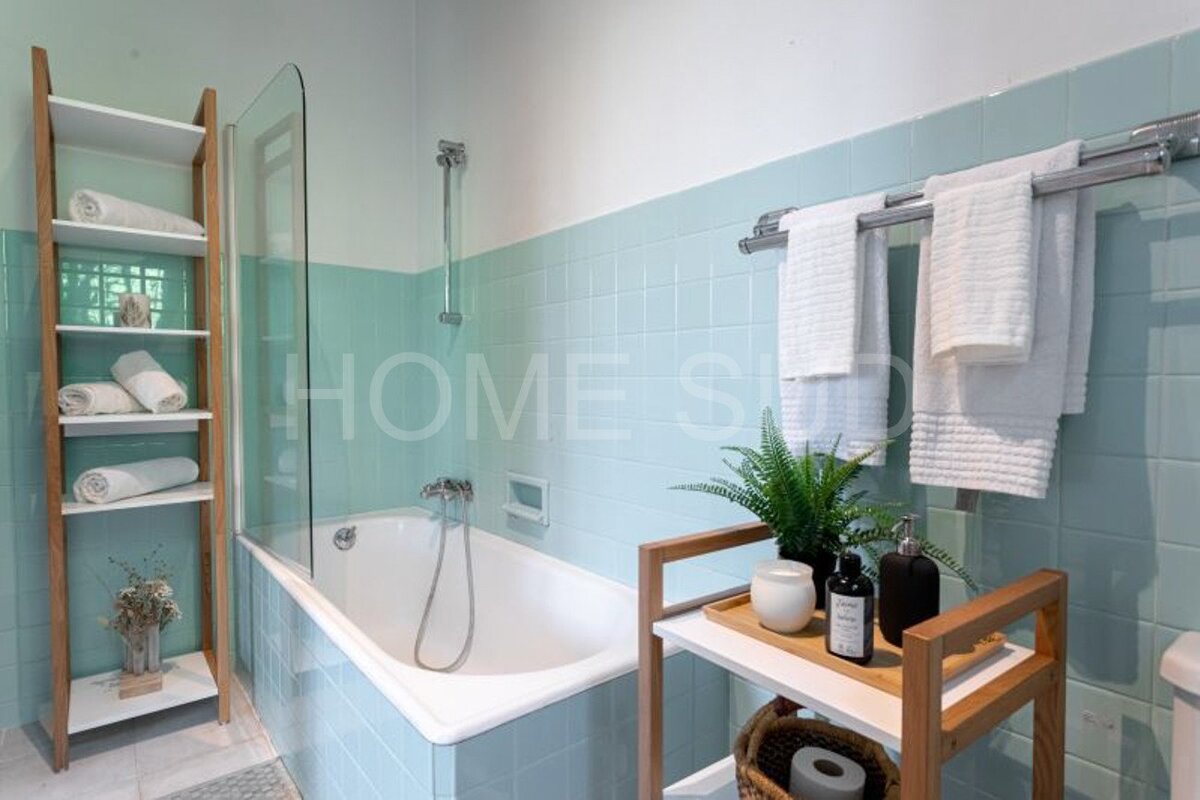 A bathtub in a bathroom with the word home on the wall