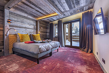 A bedroom with a large bed and a flat screen tv