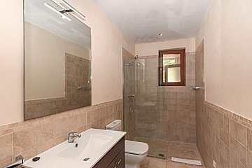 A bathroom with a toilet a sink and a mirror