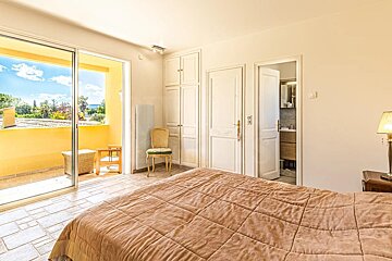 A bedroom with a sliding glass door leading to a balcony