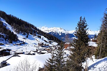 A snowy landscape with mountains in the background