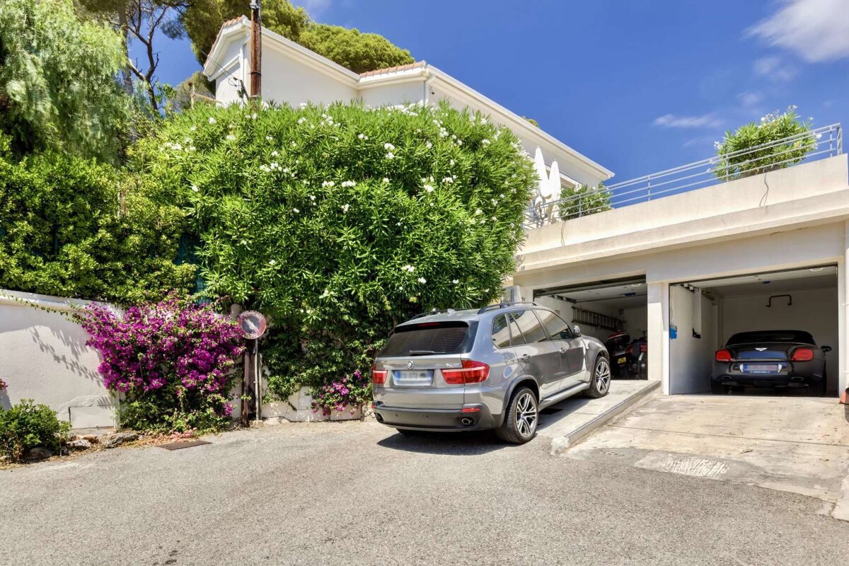 A silver bmw is parked in front of a garage