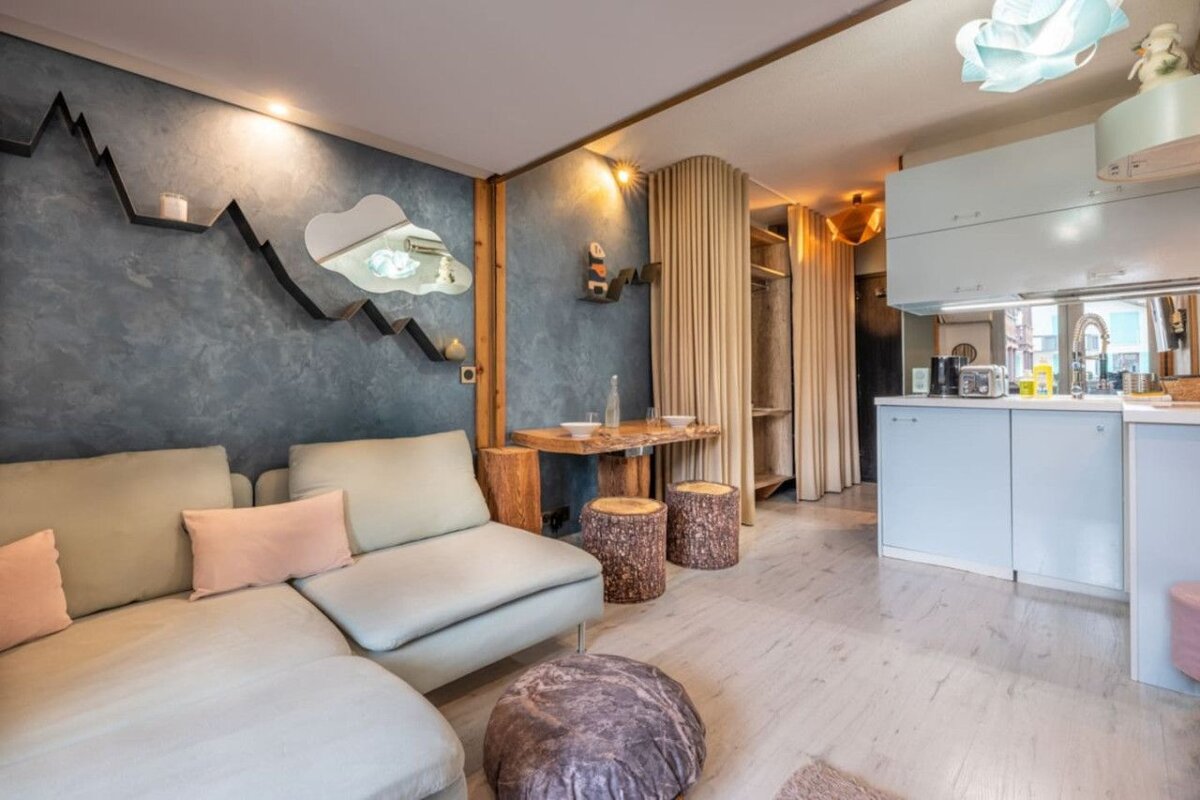 A living room with a couch and two stools