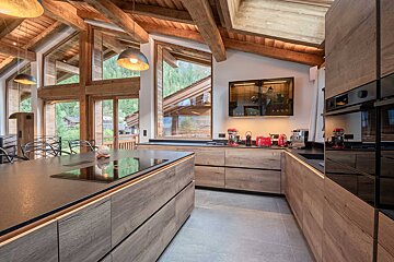 A kitchen with wooden cabinets and black counter tops