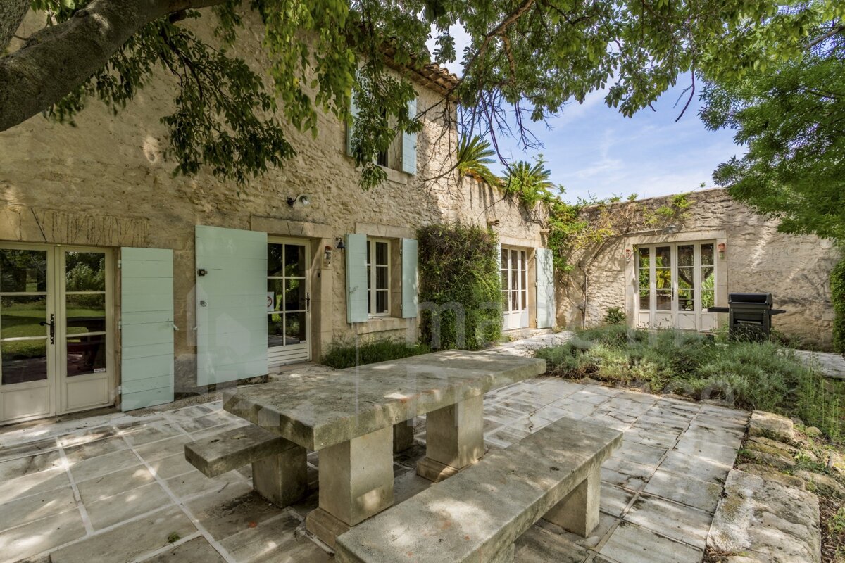 A stone house with blue shutters is for sale