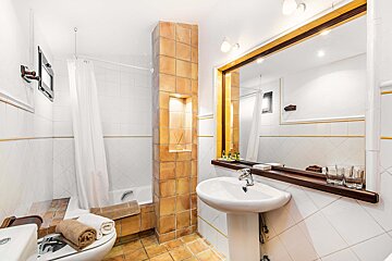 A bathroom with a sink a toilet and a mirror