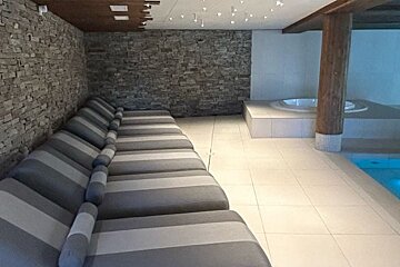A row of lounge chairs next to a swimming pool