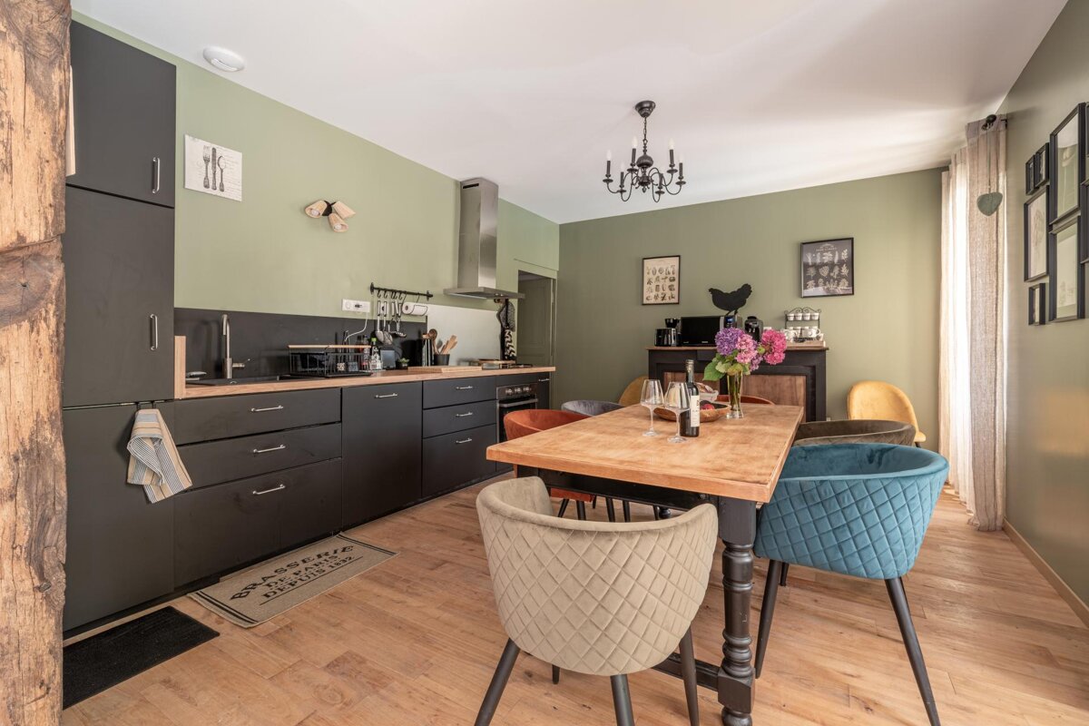 A kitchen with a table and chairs and a rug that says theatre