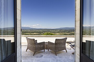 A balcony with two chairs and a table that says made in provence