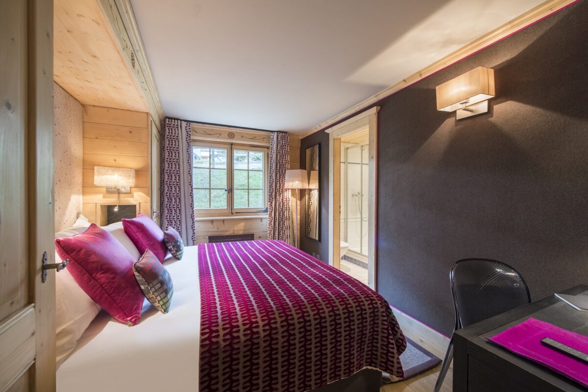 A bedroom with a large bed and a desk