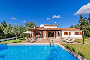 A house with a large swimming pool in front of it