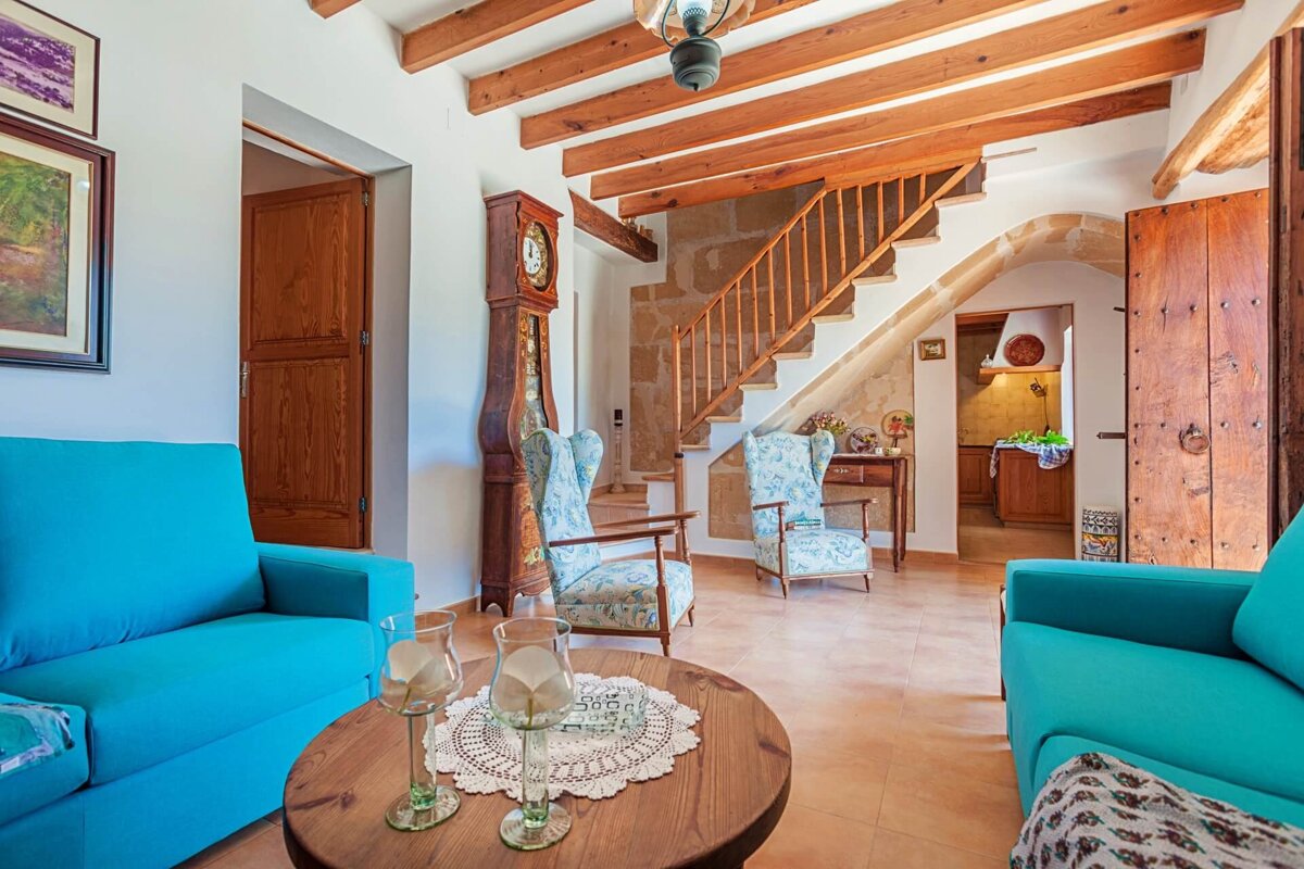 A living room with blue furniture and a clock on the wall