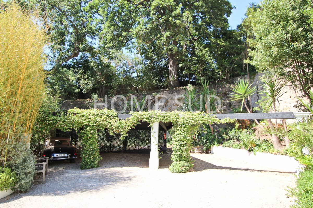 A car is parked under a pergola that says home sun