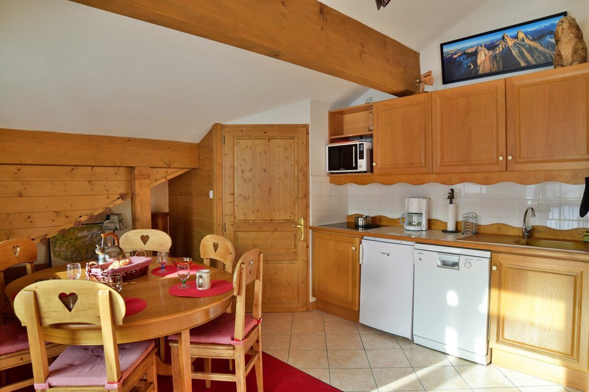 A kitchen with a table and chairs and a dishwasher
