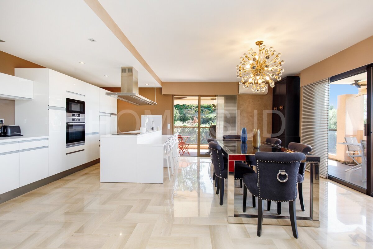 A kitchen with a dining table and chairs and a chandelier