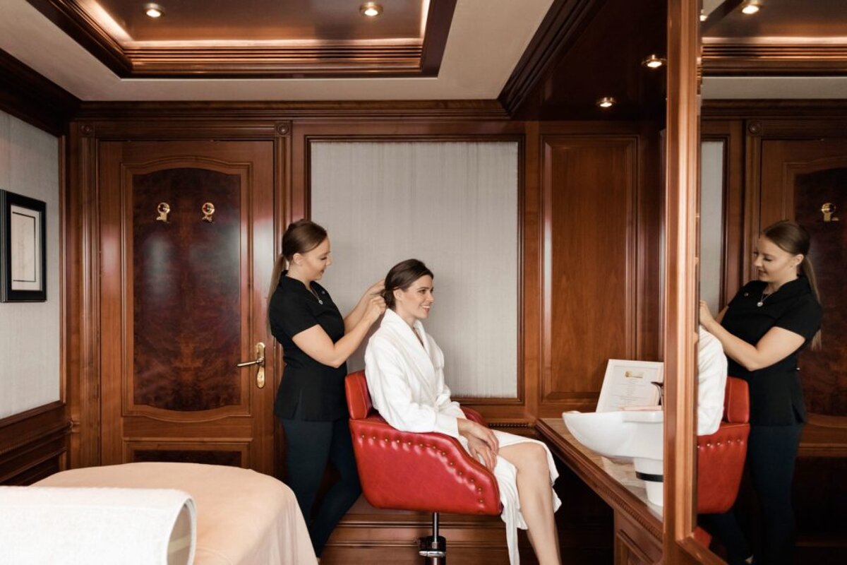 A woman in a white robe is getting her hair done