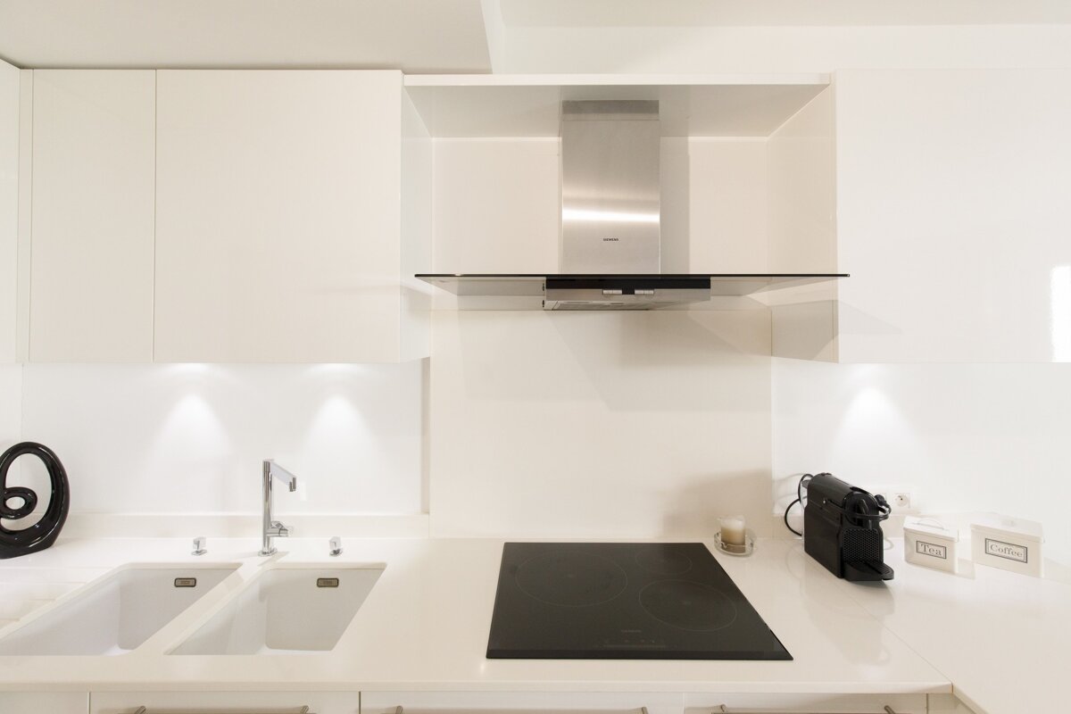 A kitchen with a stove top oven and a sink
