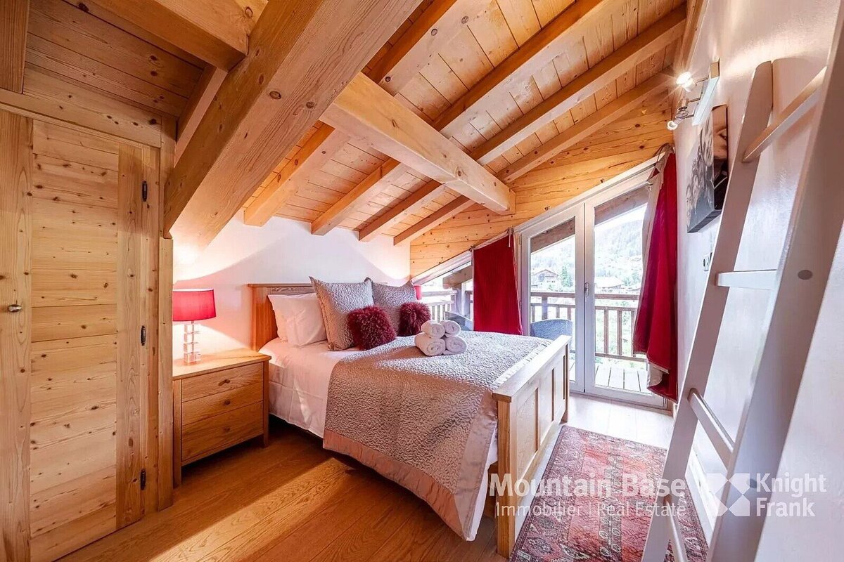 A bedroom with a bed and a sign that says mountain base knight frank