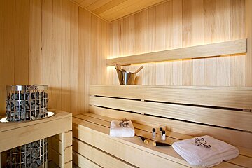 A harvia heater sits in a wooden sauna