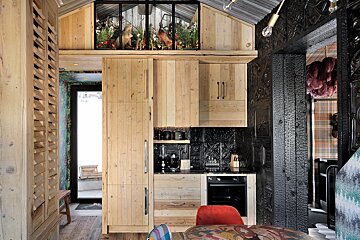 A kitchen with wooden cabinets and a red chair