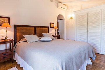 A bedroom with a large bed and two lamps