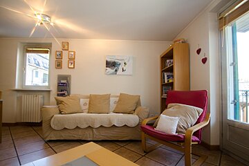 A living room with a couch a chair and a bookshelf