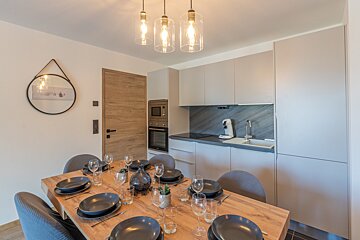 A kitchen with a table set with plates and glasses