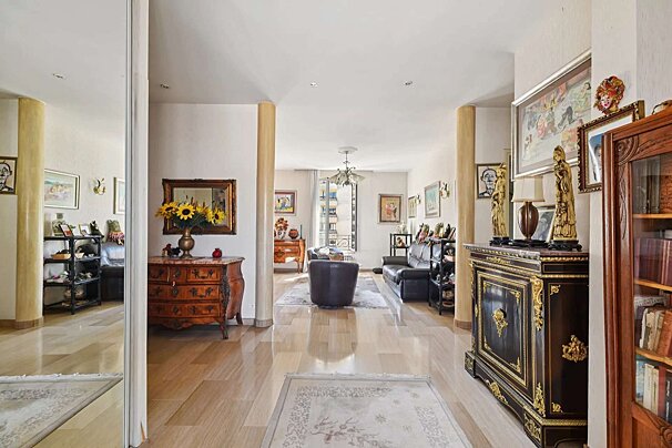 A living room with a dresser and a vase of sunflowers
