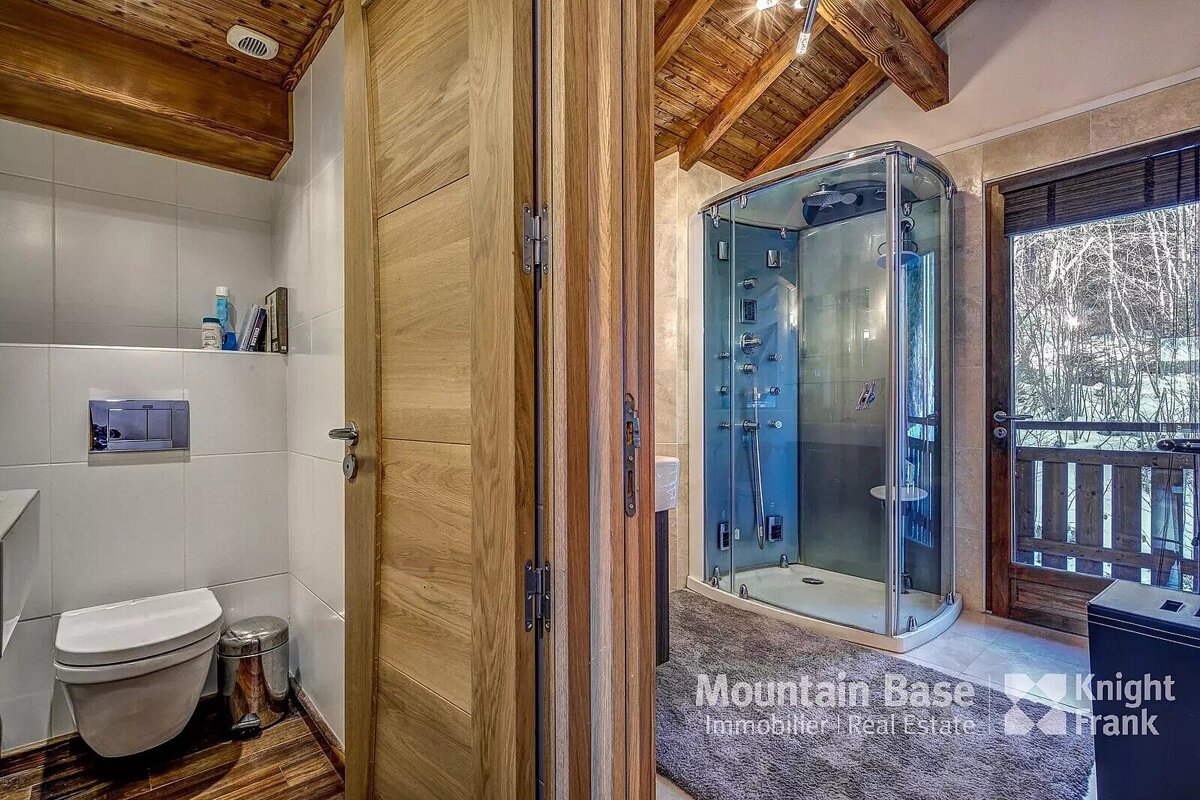 A bathroom with a toilet and shower from mountain base