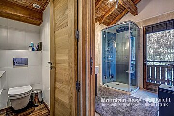 A bathroom with a toilet and shower from mountain base