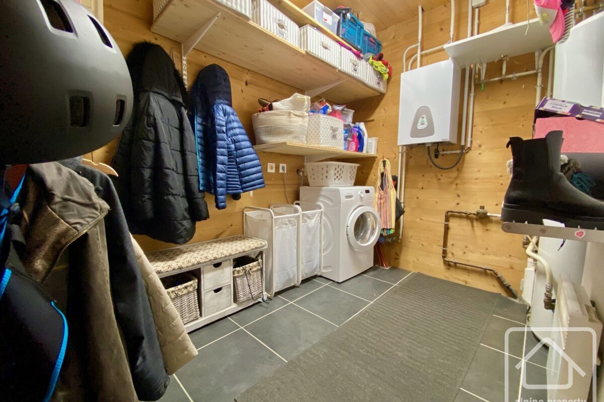 A laundry room with a washer and dryer and a heater
