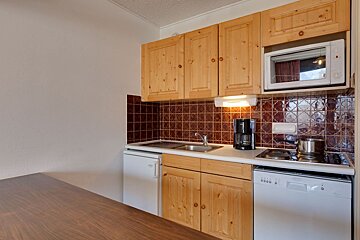 A small kitchen with wooden cabinets and a dishwasher
