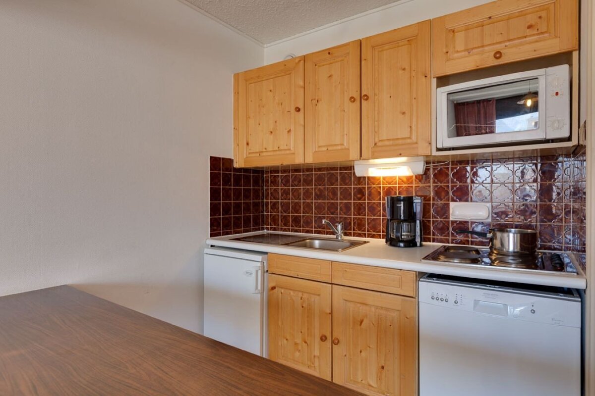 A small kitchen with wooden cabinets and a dishwasher