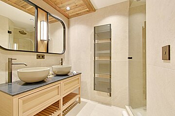 A bathroom with two sinks and a towel rack