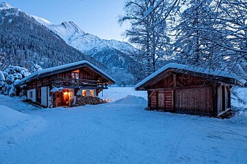 A snowy cabin with a mountain in the background