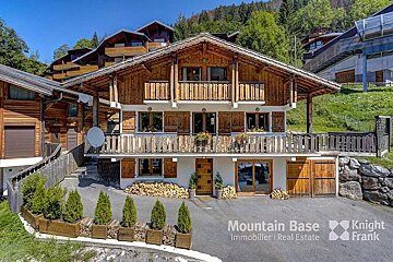 A mountain base logo is on the side of a house