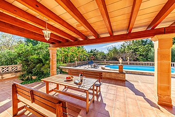 A patio with a table and chairs and a swimming pool