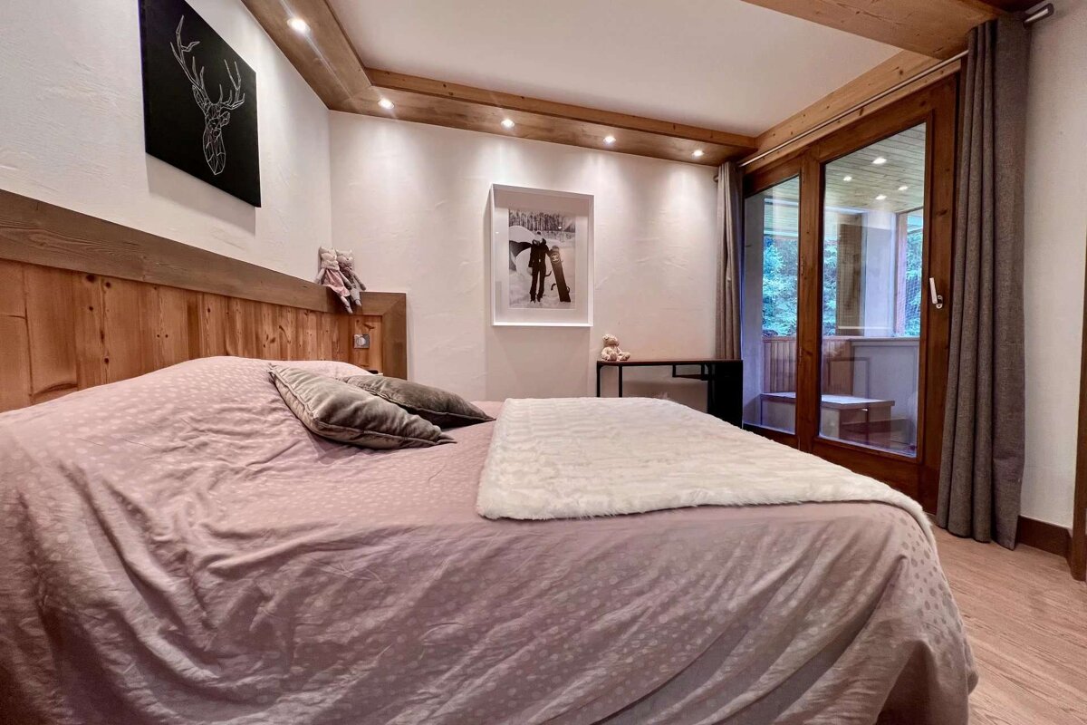 A bedroom with a large bed and a painting of skis on the wall