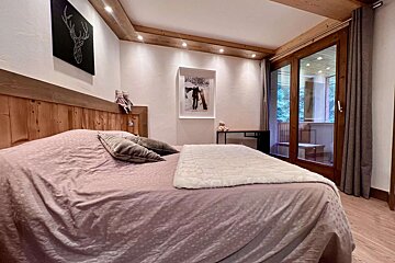 A bedroom with a large bed and a painting of skis on the wall