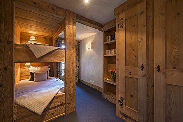 A bedroom with a bunk bed and a bookshelf