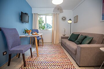 A living room with a couch and two chairs