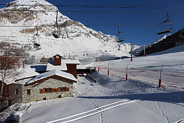 A ski lift is going up a snow covered mountain
