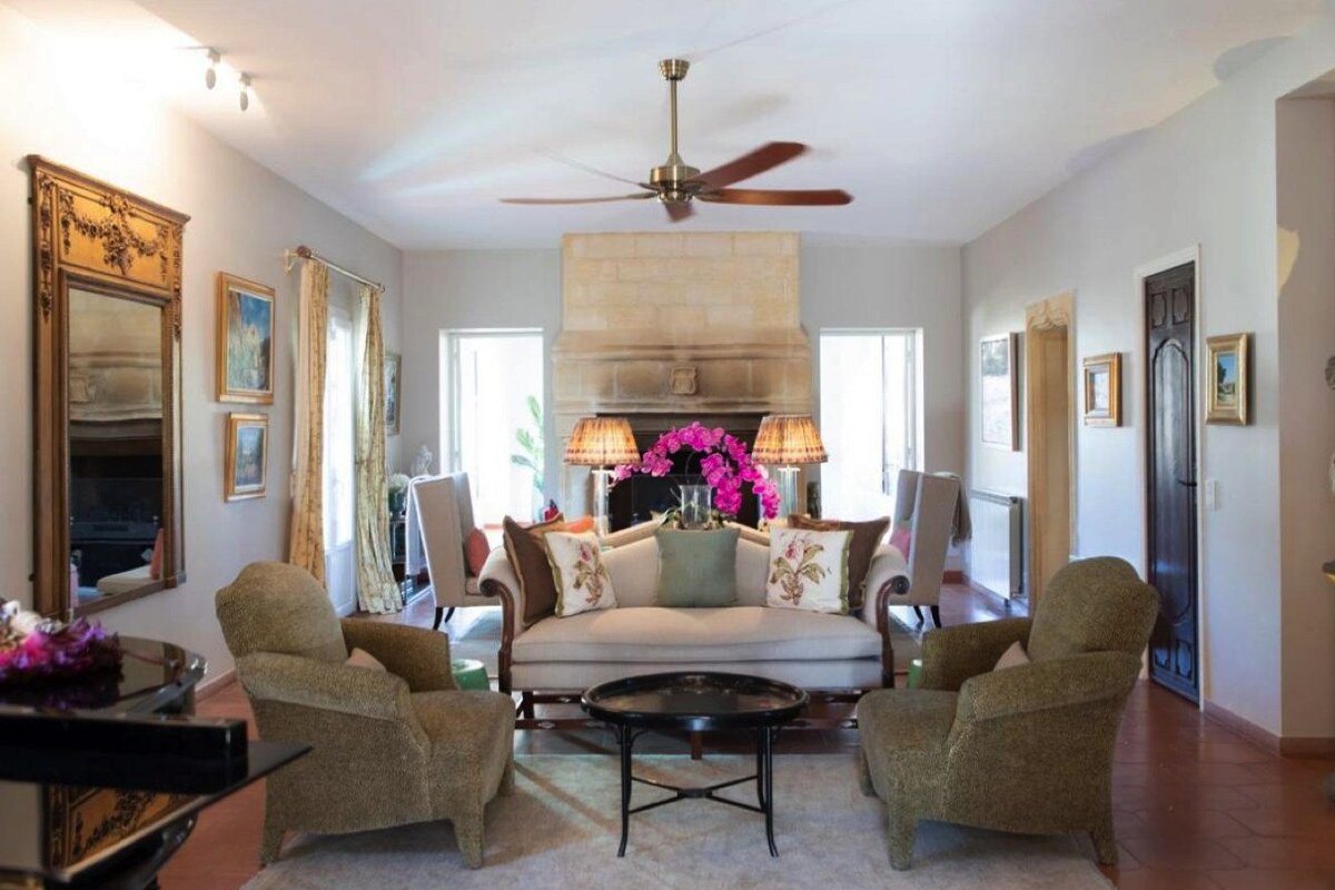A living room with a couch and chairs and a ceiling fan