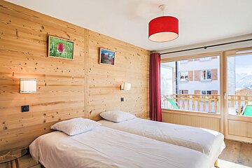 A bedroom with two beds and a red lamp